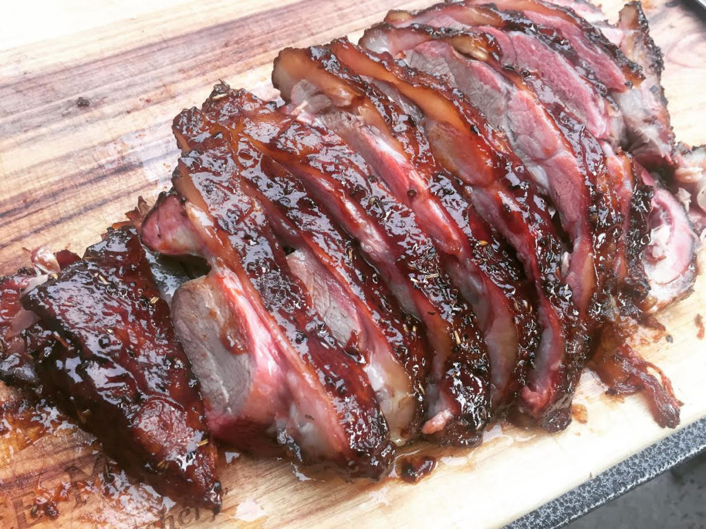 Smoked lamb shoulder - sliced on wooden chopping board