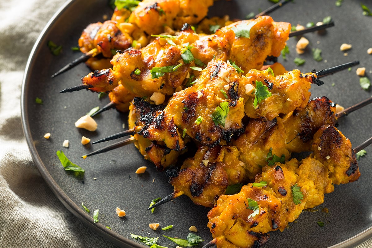 Satay Chicken Tenderloins Skewers on black plate